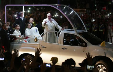 Pope Francis, right, accompanied by Cardinal Luis Antonio Tagle, left, archbishop of Manila, waves on his Popemobile during his motorcade upon arrival in Manila, Philippines, Thursday, Jan. 15, 2015
