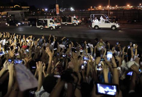 Pope Francis waves to the crowds upon arrival at the airport in Manila January 15, 2015